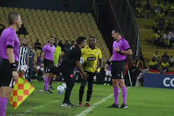 César Farías gesticulando ante el árbitro Wilmar Roldán en el Estadio Monumental.